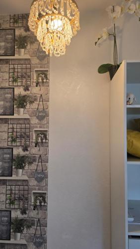 a chandelier hanging from a brick wall with plants at Studio - Café Princ pod Hradem, KLIMA, WiFi in Šternberk