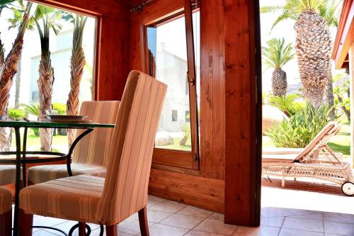 a porch with a table and chairs and palm trees at Suite & Sea - Apulian Stay Group in Rome
