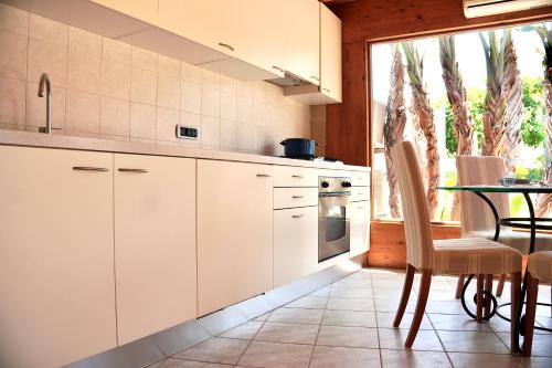 a kitchen with white cabinets and a table and a window at Suite & Sea - Apulian Stay Group in Rome