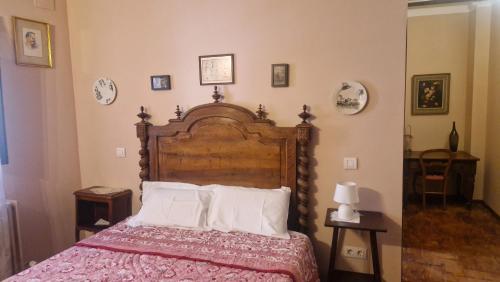 a bedroom with a large wooden bed with white pillows at Casa palaciega Doña Leocadia in Viana