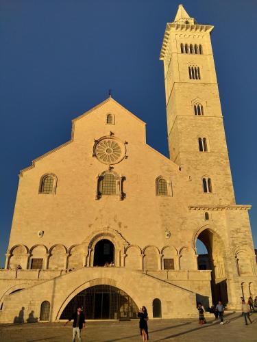 a building with a tower with a clock on it at Monolocale prezioso in Trani
