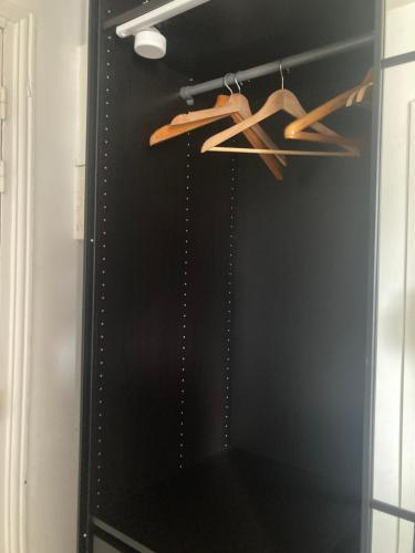 une armoire noire avec des cintres en bois dans une cuisine dans l'établissement Lovely Paris appartment, à Paris