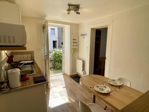 une cuisine avec une table en bois et une salle à manger dans l'établissement S19 Parking 1 chambre 1 à 2 personnes, facile d'acces A77, Nevers Magny Cours, à Imphy