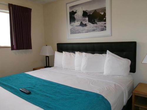 a bed in a hotel room with a remote control on it at Seahorse Oceanfront Lodge in Lincoln City