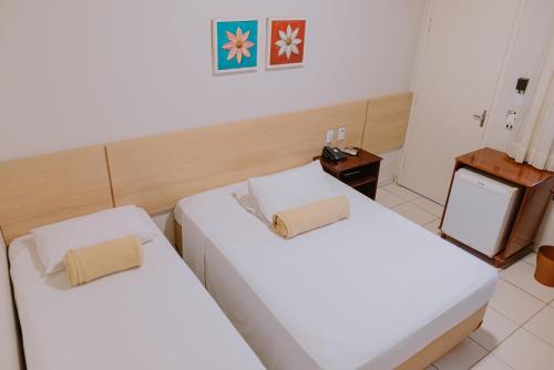 two beds in a hotel room with white sheets at Lago Da Palma in Palmas