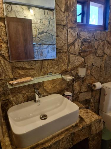 une salle de bain avec un lavabo et un miroir et des toilettes dans l'établissement Liyon Rest sigiriya, à Sigirîya