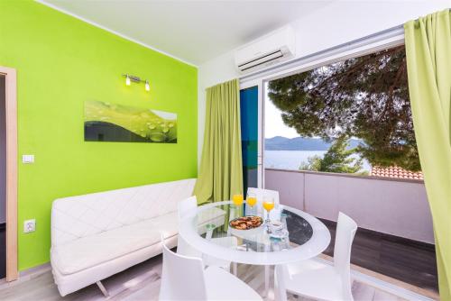 a living room with a white couch and a glass table at Beach Villa Ratac in Slano