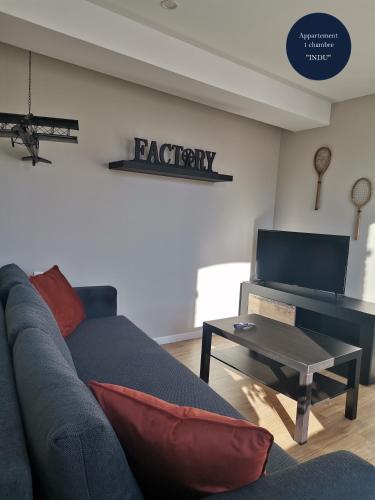 a living room with a couch and a table at Les Bras de Morphée in Avize