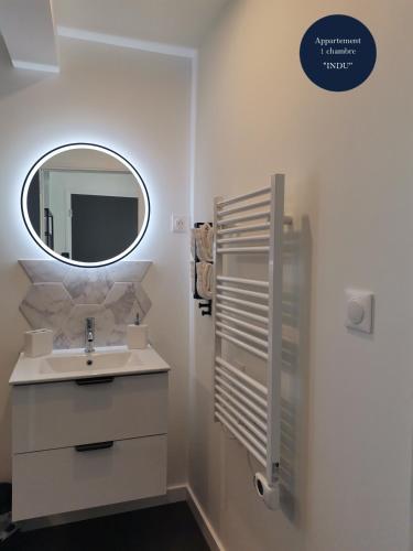 a white bathroom with a sink and a mirror at Les Bras de Morphée in Avize