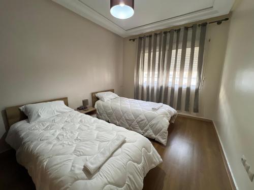 a bedroom with two beds and a window at Luxurious and Pleasant Apartment in Tangier