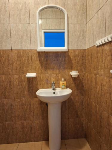 a bathroom with a sink and a mirror and a window at Casa Nicolas in Costinesti