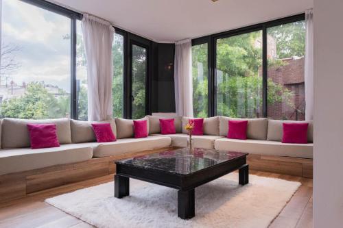 - un salon avec un grand canapé et des oreillers roses dans l'établissement Fliphaus Villa Salvador 4600 - 5 Bd Unique Villa Pool & BBQ Plaza Armenia, à Buenos Aires