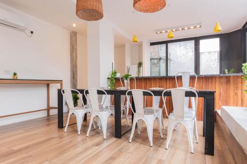 une salle à manger avec une table et des chaises blanches dans l'établissement Fliphaus Villa Salvador 4600 - 5 Bd Unique Villa Pool & BBQ Plaza Armenia, à Buenos Aires
