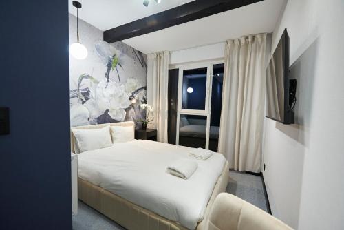 a bedroom with a white bed and a window at Villa Scolia in Niechorze