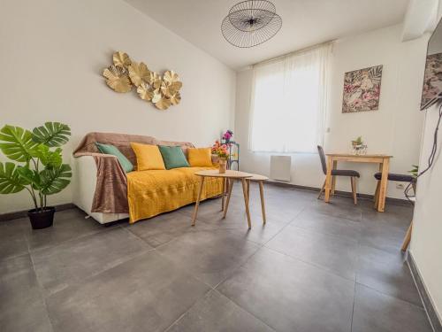 una sala de estar con un sofá y una mesa en Le Gresset Entre Calme Et Centre D'Amiens, en Amiens
