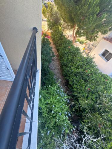 a balcony with a fence and some bushes at Olympus Holiday villa in Pissouri