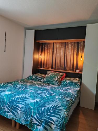 une chambre avec un lit avec une couette bleue dans l'établissement Me Lady's Cocoon 3 étoiles, à Capbreton