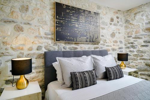 a bedroom with a bed with pillows and two lamps at Chrissi Seastar in Skala Sotiros