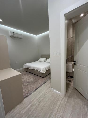 a white bedroom with a bed and a bathroom at فيلا سورا 2 in Buraydah