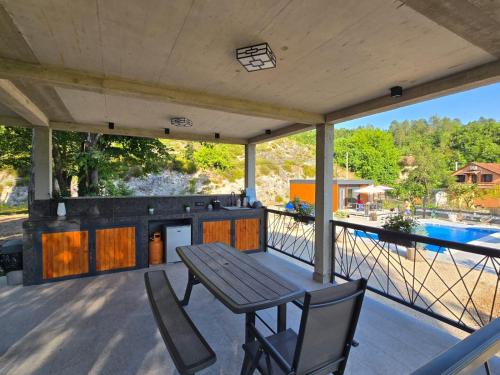 a patio with a table and chairs and a swimming pool at Villa Krivokapic in Trebinje