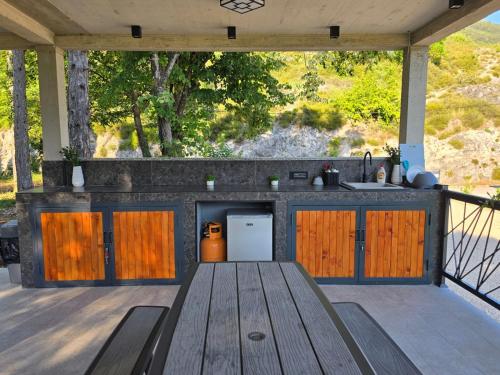 an outdoor kitchen with a wooden counter and a table at Villa Krivokapic in Trebinje