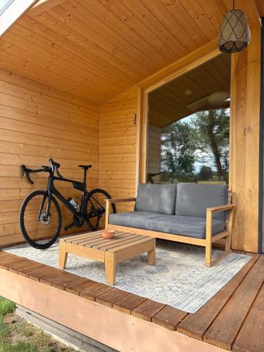 a bike parked on a porch with a couch and a bench at 108 - Tiny House mit Blick ins Grüne in Bleckede