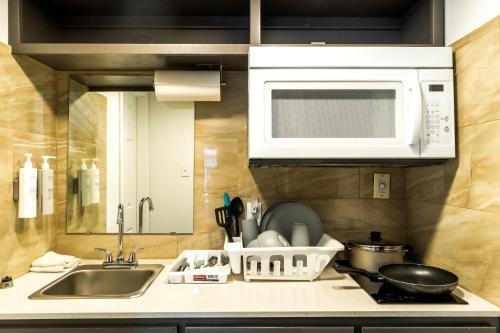 a kitchen with a sink and a microwave at Town Place Studio in Snyder