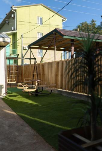 a backyard with a swing and a wooden fence at Нептун in Gribovka