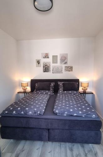 a large bed in a room with two lamps at Apartment am Mühlenteich in Weyhausen