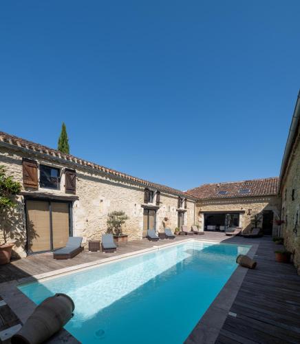 une piscine dans la cour d'un immeuble dans l'établissement Domaine de Pourrouquet - Chambres d'hôtes, à Vic-Fezensac