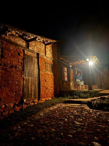 a brick building with a light on the side of it at Cantinhos da Mata Suítes Rústicas de Luxo Serra do Cipó MG in Serra do Cipo