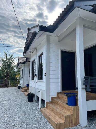 a row of white houses with wooden stairs at TTS Staycation Chalet in Penarek