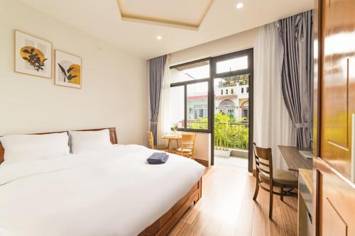 a hotel room with a bed and a balcony at Close to My Khe Beach I Food street I Sóng Homestay in Da Nang