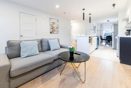 a living room with a couch and a table at Longueuil New Stylish 3-BDR free parking close to Dix 30&DT in Longueuil
