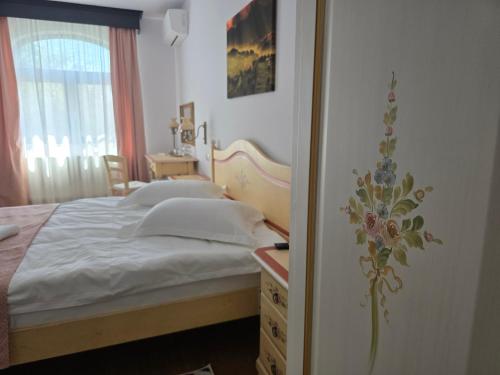 a bedroom with a bed and a desk and a window at Pensiunea Cocosel in Căstău