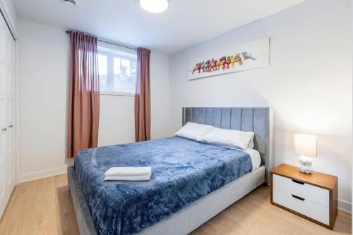 ein Schlafzimmer mit einem blauen Bett und einem Fenster in der Unterkunft Longueuil New Stylish 3-BDR free parking close to Dix 30&DT in Longueuil