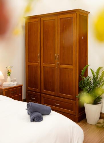 a bedroom with a large wooden cabinet and a blue towel on a bed at Close to My Khe Beach I Food street I Sóng Homestay in Da Nang
