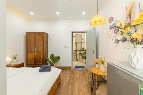 a room with a bed and a vase of flowers at Close to My Khe Beach I Food street I Sóng Homestay in Da Nang