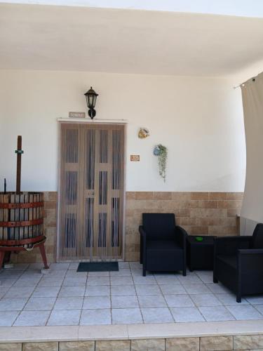 a room with two chairs and a wooden door at La Casa Del Nonno in Ischitella