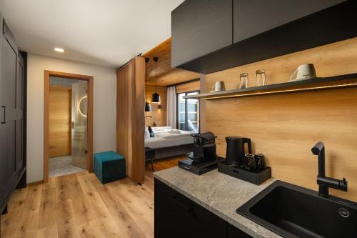 a kitchen with a sink and a room with a bed at Hunderesort Waldeck - 4 Sterne Urlaub mit Hund in Philippsreut