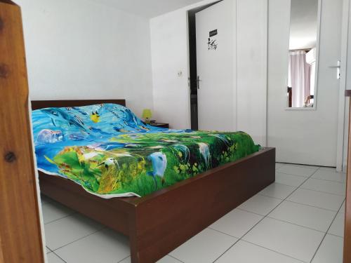une chambre avec un lit avec une couette colorée dans l'établissement Front de Mer, à Saint-Mandrier-sur-Mer