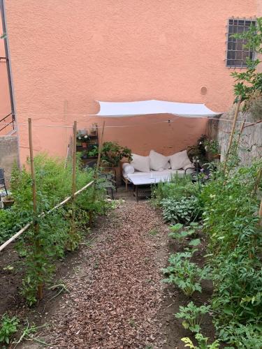a garden with a couch sitting under a building at La Meridiana in Vicopisano