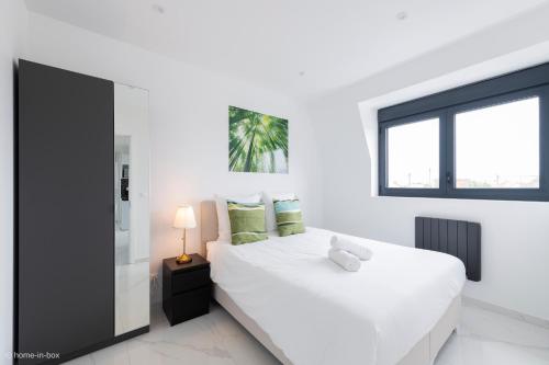 - une chambre blanche dotée d'un lit blanc avec un ours en peluche dans l'établissement Moderne F2 proche ORLY, Paris, à Paray-Vieille-Poste