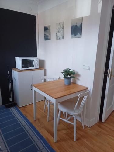 a table and chairs in a kitchen with a microwave at Gamla Skolan i Siknäs in Töre