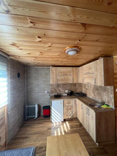 a kitchen with wooden ceilings and a wooden table at Jovovic House in Žabljak