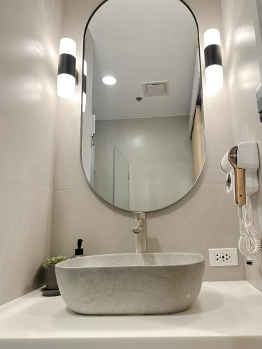a bathroom with a sink with a large mirror at Yugen Suites at Pico De Loro in Nasugbu