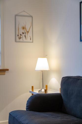 a living room with a blue chair and a lamp at Spacious 220 sqm Apartment with 4 Bedrooms in Tórshavn