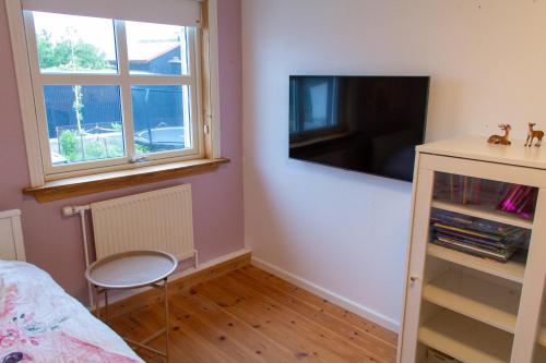 a bedroom with a flat screen tv on a wall at Spacious 220 sqm Apartment with 4 Bedrooms in Tórshavn