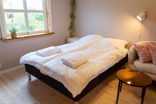 a bed with pillows on it in a room with a window at Spacious 220 sqm Apartment with 4 Bedrooms in Tórshavn