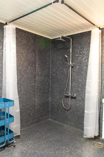 a shower in a room with a wall at Spacious 220 sqm Apartment with 4 Bedrooms in Tórshavn
